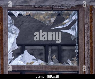 Glasbruch, Gefahr. Großes Fenster mit blauer Glaszerstörung Stockfoto