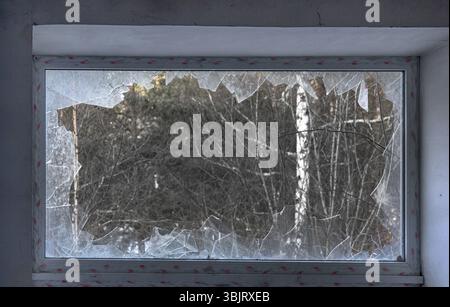 Glasbruch, Gefahr. Großes Fenster mit blauer Glaszerstörung Stockfoto