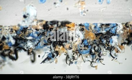 Kunststoff wird in Wasserbecken und schrittweise durch Sonne und Wellen zerstört. Plastische Teilchen sammeln sich in Felder und Klumpen auf der Wasseroberfläche und in der t Stockfoto