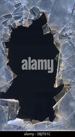Hintergrundfenster bei Unruhen kaputt. Glasstücke Loch Chaos Stockfoto