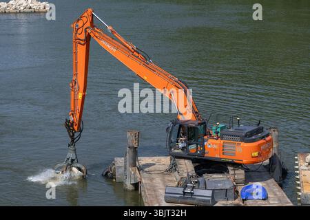Villey-le-SEC, Frankreich - Blick auf einen orangen Raupenbagger Hitachi ZX350-7LC auf einem Lastkahn für Flussarbeiten an der Mosel. Stockfoto