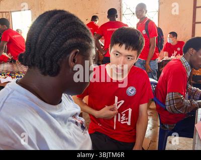 (250617) -- BISSAU, 17. Juni 2025 (Xinhua) -- der chinesische Dolmetscher Fan Jiawei dient einem lokalen Schüler an der Samora Moises Machel High School in Bissau, Hauptstadt von Guinea-Bissau, 13. Juni 2025. UM MIT 'Roundup: Chinesische Ärzte bringen kostenlose Kliniken zu Schulen in Guinea-Bissau' (die 20. Charge des chinesischen medizinischen Teams in Guinea-Bissau/Handout Via Xinhua) Stockfoto