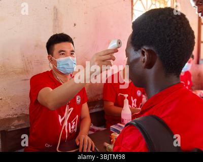 (250617) -- BISSAU, 17. Juni 2025 (Xinhua) -- der chinesische Arzt Chen Qiuyu misst die Körpertemperatur eines lokalen Schülers an der Samora Moises Machel High School in Bissau, Hauptstadt von Guinea-Bissau, 13. Juni 2025. UM MIT 'Roundup: Chinesische Ärzte bringen kostenlose Kliniken zu Schulen in Guinea-Bissau' (die 20. Charge des chinesischen medizinischen Teams in Guinea-Bissau/Handout Via Xinhua) Stockfoto