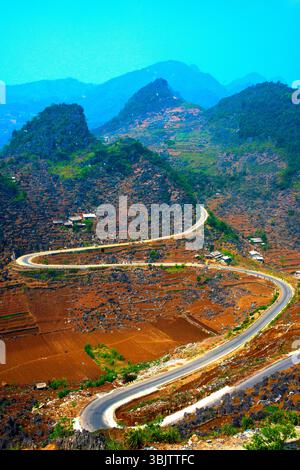 Eine gewundene Bergstraße, bekannt als „M Pass“, schlängelt sich durch die felsige Landschaft von Ha Giang im Norden Vietnams. Diese malerische Route ist berühmt für ihre Shar Stockfoto