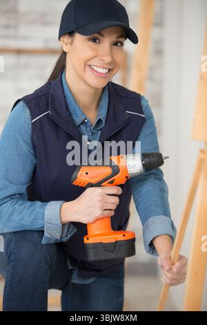 Weibliche Bauherin mit einem elektrischen Schraubendreher Stockfoto