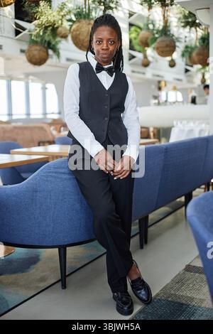 Porträt der jungen Erwachsenen Schwarzen Frau im Restaurant, die drinnen steht Stockfoto