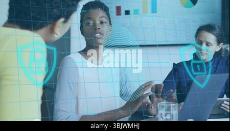 Eine afroamerikanische Frau zeigt auf einem Konferenztisch auf ein Tablet, holografische Sicherheitssymbole Stockfoto