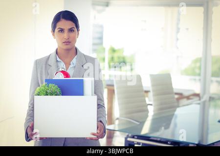 Professional steht im Konferenzraum aus Glas, in der Box mit Pflanzen und Wecker Stockfoto