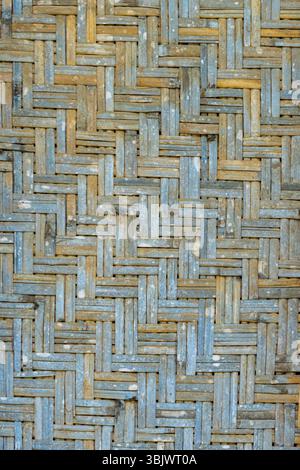 Verwitterte Holzwand mit blauem und braunem Muster. Das Muster besteht aus vielen kleinen Quadraten Stockfoto