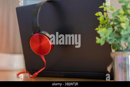 Kopfhörer und Laptop auf Holztisch. Hören von Musik, Audio und Soundkonzept. Selektiver Fokus. Stockfoto