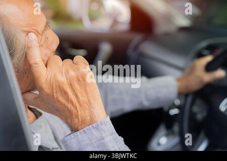 Verärgerter älterer Mann, der Auto fährt Verzweiflung nach einem Unfall, müder Mann mittleren Alters, der das Lenkrad im Auto hält, drückt die Hand an den Kopf Stockfoto