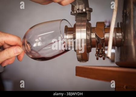 Winzer schenken Wein aus dem Fass in Glas Stockfoto