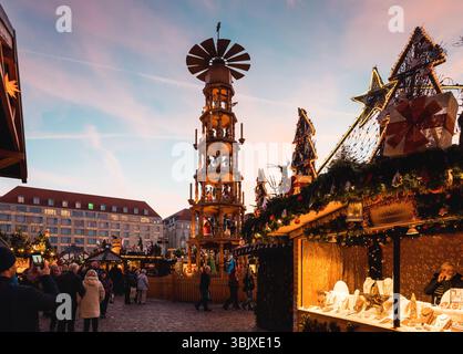 Striezelmarkt in Dresden. Weihnachtsmarkt am Altmarkt bei Sonnenuntergang mit Weihnachtspyramide, Kiosken und vielen Lichtern. Stockfoto