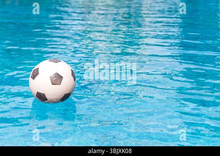 Fußball Schwimmen im Schwimmbad Stockfoto