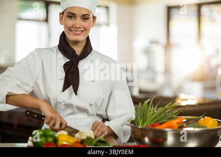 Die Chefin schneidet Pilze an Bord in der Restaurantküche mit Paprika-Spargel-Rührschüssel Stockfoto