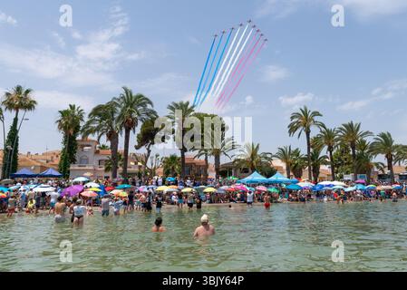 Royal Air Force Red Arrows zeigt ein Team, das über die Strände von Mar Menor fliegt, mit Menschenmassen am Strand und im Wasser. AIRE25 Airshow, San Javier Stockfoto