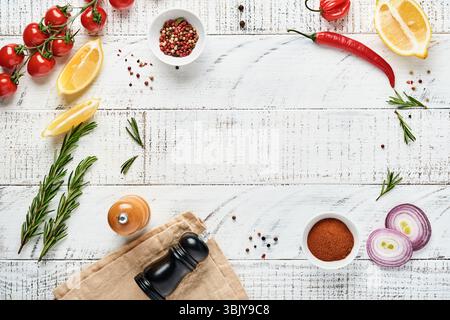 KochHintergrund mit Gewürzen: Pfeffer, Rosmarin, Paprika, Zitrone, Zwiebeln, Spargel, Olivenöl, Tomaten, Parmesankäse, Kochen Stockfoto