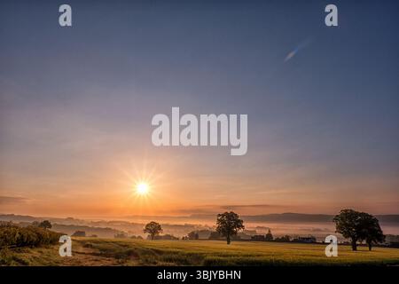 Big Sky Misty Dawn über die Farm Fields & Shirelands Valley: Blick von Woolston in Richtung Church Stretton, The Marches, South Shropshire West Midlands. Stockfoto