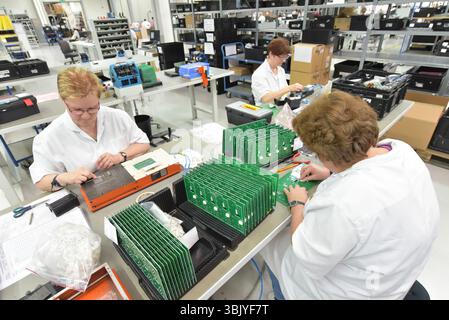 Frauen bei der Herstellung von Mikroelektronik in einer modernen Industriefabrik Stockfoto