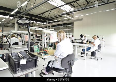 Frauen bei der Herstellung von Mikroelektronik in einer modernen Industriefabrik Stockfoto