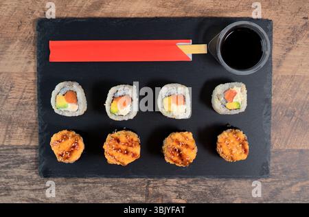 Sushi-Rolle auf dem schwarzen Teller. Japanisches Essen. Draufsicht. Stockfoto