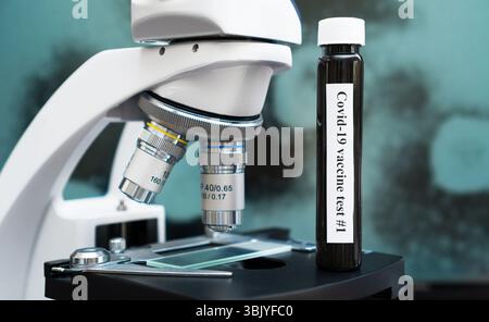 Coronavirus-Impfstoff steht in der Nähe des Mikroskops im Labor. Stockfoto
