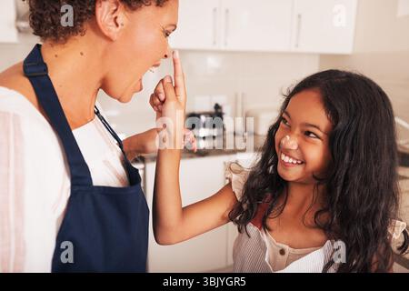 Enkeltochter und Großmutter haben Spaß zusammen in der Küche, während sie Cupcakes backen Stockfoto