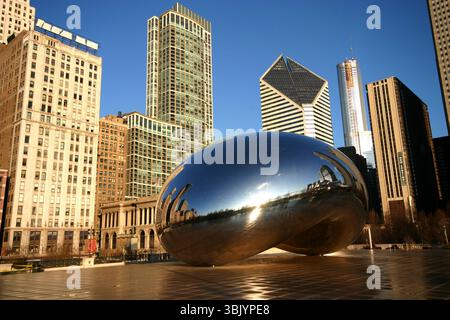 Cloud Gate, bekannt als „The Bean“, spiegelt die Skyline von Chicago im Millennium Park an einem klaren Morgen wider, umgeben von Wolkenkratzern und blauem Himmel. Stockfoto