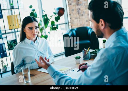 Professionelles Treffen am Arbeitsplatz zwischen Kollegen, bei dem Projektziele und -Strategien in einer modernen Büroumgebung diskutiert werden Stockfoto
