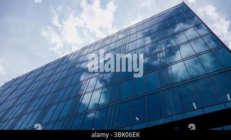 NEWCASTLE, Großbritannien - 13. JUNI 2025 - Niedrigwinkelansicht eines modernen Glasgebäudes mit Wolken in Newcastle, Großbritannien Stockfoto