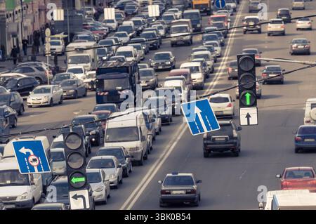 Grüne Verkehrsampen und blaues Schild mit verschwommenen Autos Stockfoto