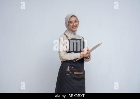 Asiatische junge muslime mit Hijab und schwarzer Schürze Stockfoto