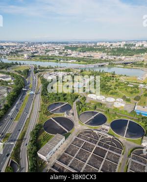 Umweltfreundliche Luftaufnahme der Abwasseraufbereitungsanlage in der Nähe von Lyon, Frankreich, mit städtischer Skyline – nachhaltiges Wassermanagement und Umweltschutz Stockfoto