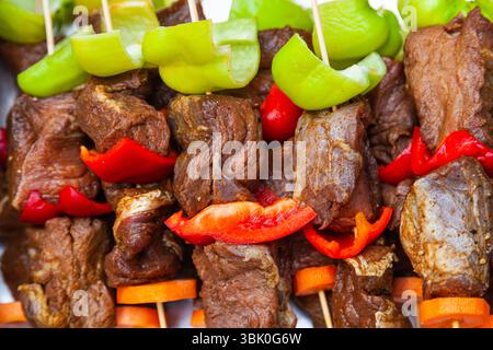 Lammspieße mit Salatschoten auf Holzspießen, Nahaufnahme. Stockfoto