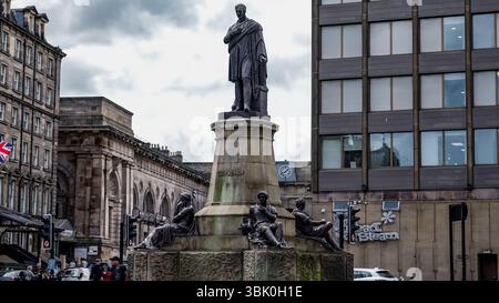 NEWCASTLE, Vereinigtes Königreich - 13. JUNI 2025 - Denkmal für George Stephenson, den Vater der Eisenbahn, in Newcastle upon Tyne, Vereinigtes Königreich, mit Newcastle Central Station in t Stockfoto