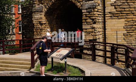 NEWCASTLE, Großbritannien - 13. JUNI 2025 - Touristen gehen durch den Eingang des mittelalterlichen Newcastle Castle und Black Gate in Newcastle upon Tyne, Großbritannien, enjo Stockfoto