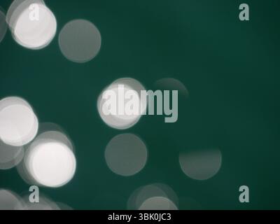 Draufsicht auf die Wasseroberfläche. Verschwommene Unschärfe mit Bokeh-Effekt. Sonnenlicht auf dem Wasser. Hintergrund abstrakte Hintergrundstruktur. Stockfoto