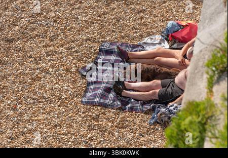 Portsmouth Hampshire England Vereinigtes Königreich. 15.06.2025. Mann Frau und Hund entspannen am Strand in Portsmouth, Südengland, Großbritannien Stockfoto