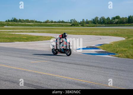 Motorradfahrer auf der Porsche Rennstrecke in eine Kurve Stockfoto