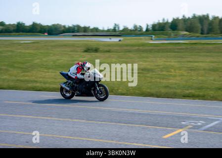 Motorradfahrer auf einem schwarzen Sportrad auf der Porsche-Strecke Stockfoto