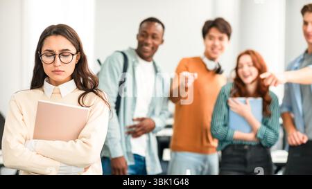 Die Leute spotten und machen sich über traurige Frau lustig Stockfoto