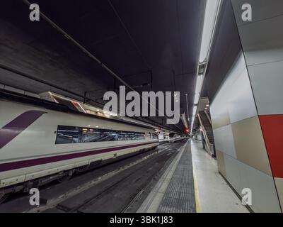 BARCELONA, SPANIEN - 12. APRIL 2025: AVE-Hochgeschwindigkeitszüge von Siemens Velaro warten auf gegenüberliegenden Gleisen in der unterirdischen Halle der Barcelona Sants Street Stockfoto