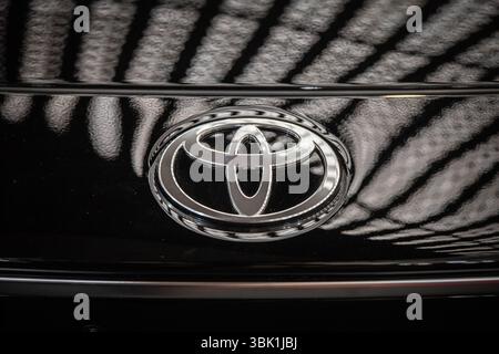 BELGRAD, SERBIEN - 22. MÄRZ 2025: Verchromtes Toyota-Emblem auf der tiefschwarzen Front eines Autos in Belgrad, Serbien. Toyota ist ein japanischer Automobilhersteller Stockfoto