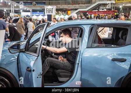 BELGRAD, SERBIEN - 15. MÄRZ 2025: Mann sitzt auf dem Fahrersitz eines Fiat im Belgrader Händlerbetrieb, Hand am Lenkrad, er inspiziert Kontrollen, illustr Stockfoto
