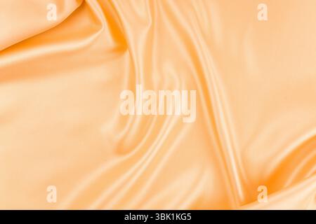 Glatte, elegante orangefarbene Seide kann als Hintergrund verwendet werden. Stockfoto