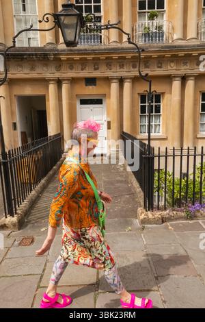 England, Somerset, Bath, farbenfroher Charakter, der an georgianischen Häusern im Circle vorbeiläuft Stockfoto
