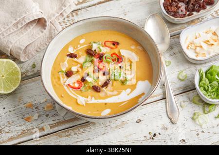 Cremige Linsensuppe mit Zitronengras, Kokosmilch und rotem Chili, serviert in einer Schüssel – warm, würzig und pflanzlich, perfekt zum Mittag- oder Abendessen. Stockfoto