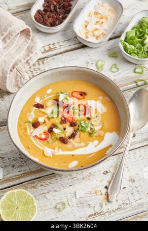 Cremige Linsensuppe mit Zitronengras, Kokosmilch und rotem Chili, serviert in einer Schüssel – warm, würzig und pflanzlich, perfekt zum Mittag- oder Abendessen. Stockfoto