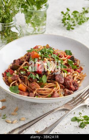 Mediterrane Gemüsebolognese, serviert auf einem weißen Teller – eine herzhafte Pastasauce auf Pflanzenbasis, perfekt zum Mittag- oder Abendessen, leicht. Stockfoto