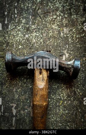 Die Nahansicht erfasst den schweren Hammer, der auf einer Holzoberfläche aufliegt Stockfoto